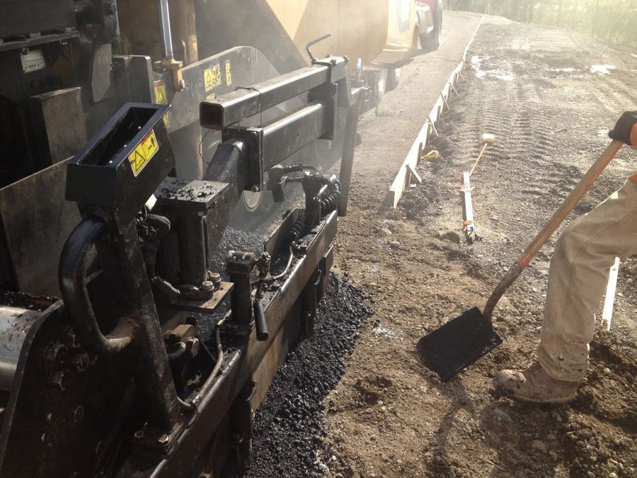 Paving machinery laying material at dawn